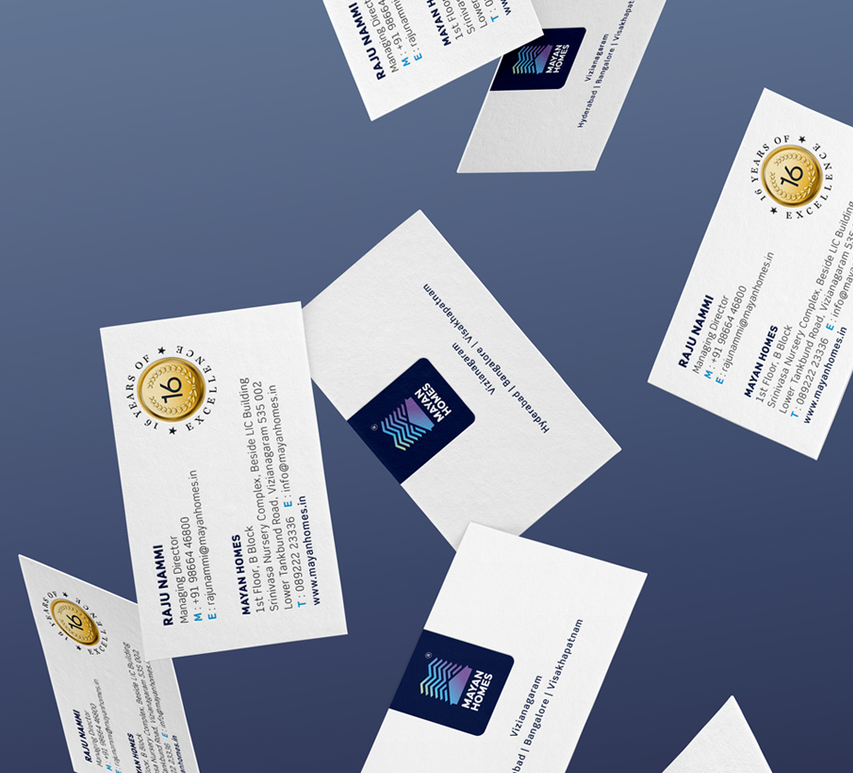 Mayan Homes business cards for real estate company featuring logo, contact details, and 16 years of excellence badge on blue background